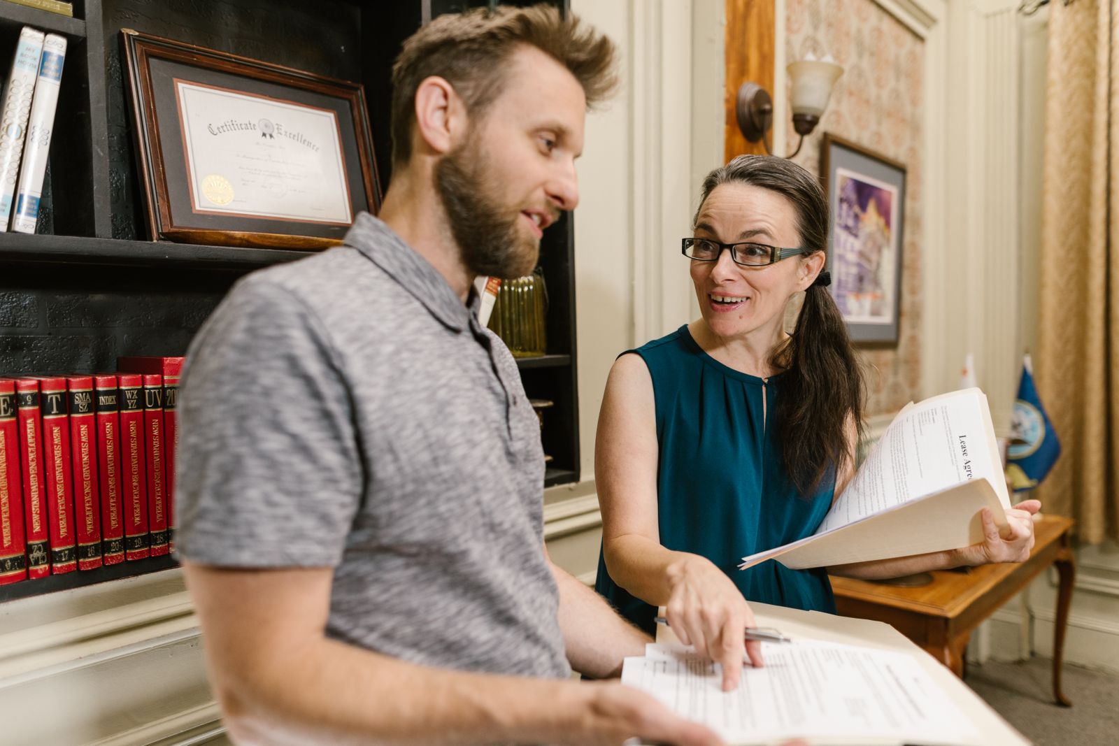 Legal team reviewing claimant documents together at a desk lined with medical-legal reference volumes